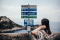 Young woman looking at sign table for direction.Wman on vacation in Italian coast.South cosat of Italy, Amalfi and Positano sights