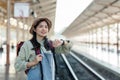 Young woman looking at smart watch with backpack. Young woman waiting for train