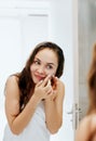 Young woman  looking and squeeze  acne on a face in front of the mirror. Ugly problem skin girl, teen girl having pimples. Skin ca Royalty Free Stock Photo