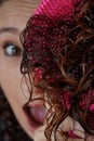 Young woman looking straight ahead in which only half of the face is seen and the other half the brush with her curly hair Royalty Free Stock Photo