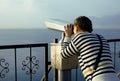 Young woman looking through telescope at sea Royalty Free Stock Photo
