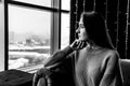 Young woman looking thoughtfully out the window on a winter day Royalty Free Stock Photo