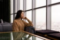 Young woman looking thoughtfully out the window on a winter day Royalty Free Stock Photo