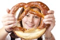 Young woman looking trough Oktoberfest Pretzel. Royalty Free Stock Photo