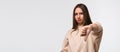 Young woman looking unhappy and angry showing dislike with thumb down, rejection concept. Copy space Royalty Free Stock Photo