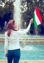 Young woman looking up on Hungarian flag at fountain, Budapest