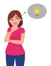 Young woman looking up, in thought bubble glowing a light bulb. Idea and creative concept. Initiate and innovation theme. Royalty Free Stock Photo