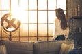 Young woman looking in window in loft apartment