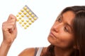 Young woman looking at yellow tablet pills Royalty Free Stock Photo