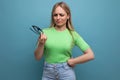 young woman looks disdainfully at the glasses in her hands on a blue background Royalty Free Stock Photo