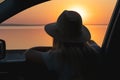 A young woman looks out the car window at the sunset on the sea.	heart made with hands Royalty Free Stock Photo