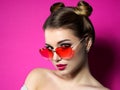 Young woman looks over heart shaped glasses
