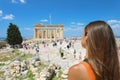 Young woman looks at Parthenon on the Acropolis of Athens, Greece. The famous ancient Greek Parthenon is the main tourist