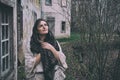 A young woman looks at the sky and dreams against the background of old houses and autumn landscape Royalty Free Stock Photo