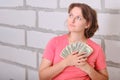 The young woman looks thoughtfully with the money in her hands. Doubts about the cost of repair of a new apartment. Copy space for Royalty Free Stock Photo