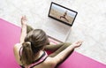 Young woman in lotus position doing yoga watching online class.Virtual yoga couch tutorial , video call education training Royalty Free Stock Photo