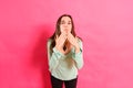 Young woman with loving attitude blows kisses with her hand looking for a partner during her single life, isolated on pink Royalty Free Stock Photo