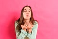 Young woman with loving attitude blows kisses with her hand looking for a partner during her single life,  on pink Royalty Free Stock Photo