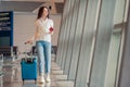 Young woman with luggage in international airport. Airline passenger in an airport lounge waiting for flight aircraft Royalty Free Stock Photo