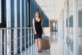 Young woman with luggage at the international airport. She is very happy of her vacation at warm country on christmas holidays Royalty Free Stock Photo