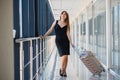 Young woman with luggage at the international airport. She is very happy of her vacation at warm country on christmas holidays Royalty Free Stock Photo