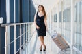 Young woman with luggage at the international airport. She is very happy of her vacation at warm country on christmas holidays Royalty Free Stock Photo