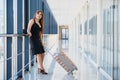 Young woman with luggage at the international airport. She is very happy of her vacation at warm country on christmas holidays Royalty Free Stock Photo