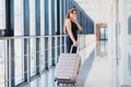 Young woman with luggage at the international airport. She is very happy of her vacation at warm country on christmas holidays Royalty Free Stock Photo