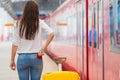 Young caucasian girl with luggage at station traveling by train Royalty Free Stock Photo