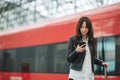 Young woman with luggage at a train station waiting for express train Royalty Free Stock Photo