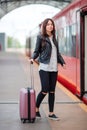 Young woman with luggage talking at train station. Caucasiam tourist waiting her express train while her vacation Royalty Free Stock Photo