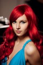 Young woman with luxurious long beautiful red hair in a blue fashionable evening dress in the rich interior. Royalty Free Stock Photo