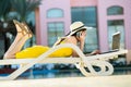 Young woman lying on beach chair working on computer laptop connected to wireless internet having conversation on mobile sellphone Royalty Free Stock Photo