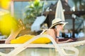 Young woman lying on beach chair working on computer laptop connected to wireless internet having conversation on mobile sellphone Royalty Free Stock Photo