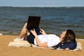 Young woman using laptop computer on a beach. Freelance work concept Royalty Free Stock Photo