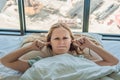 Young woman lying on a bed covered her ears because of the noise Royalty Free Stock Photo