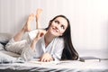 Young woman lying on the bed at home bedroom and writing into diary or planning her day, making schedule for tomorrow. Concept - r Royalty Free Stock Photo