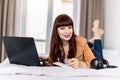 Young woman lying on bed at home, using laptop computer and making notes in her notepad, studying or working from home Royalty Free Stock Photo