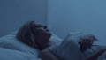 Young woman lying in the bed at night and having insomnia disease. Beautiful blond sleeping girl. Twilight in the Royalty Free Stock Photo
