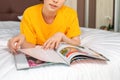 A young woman is lying on the bed and reading a magazine. Magazine close-up. Reading and recreation Royalty Free Stock Photo