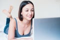 Young woman lying on the bed and using laptop Royalty Free Stock Photo