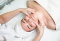 Young woman lying with closed eyes and having face and head massage Royalty Free Stock Photo