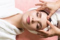 Woman lying with closed eyes and having face or head massage in spa Royalty Free Stock Photo