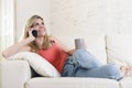 Young woman lying comfortable on home sofa couch talking on mobile phone smiling happy Royalty Free Stock Photo