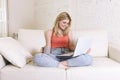 Young woman lying comfortable on home sofa using internet in laptop computer smiling happy Royalty Free Stock Photo