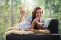 Young woman lying on a couch holding a bowl of yogurt Royalty Free Stock Photo