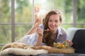 Young woman lying on a couch holding a salad bowl Royalty Free Stock Photo