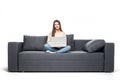 Young woman lying on couch and using laptop at home Royalty Free Stock Photo