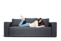 Young woman lying on couch and using laptop at home Royalty Free Stock Photo