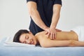 Young woman is lying down when man doing massage of her back at spa Royalty Free Stock Photo